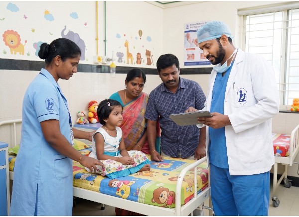 Pediatrician gently checking a child's heart with a stethoscope at Krishna Hospital, Tirunelveli